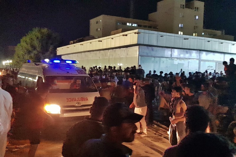 Iraq Hospital Fire People gather outside a COVID-19 hospital in Nasiriyah, Iraq, early Tuesday, July 13, 2021. A catastrophic blaze erupted at the coronavirus hospital ward. It was the second time a large fire killed coronavirus patients in an Iraqi hospital this year. (AP Photo)