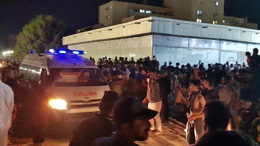 People gather outside a COVID-19 hospital in Nasiriyah, Iraq, early Tuesday, July 13, 2021. A catastrophic blaze erupted at the coronavirus hospital ward. It was the second time a large fire killed coronavirus patients in an Iraqi hospital this year. (AP Photo)