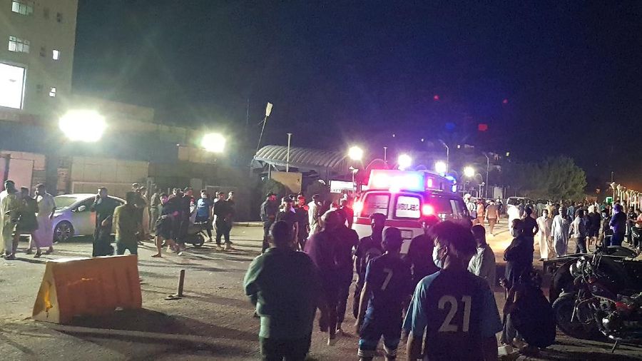 People gather outside a COVID-19 hospital in Nasiriyah, Iraq, early Tuesday, July 13, 2021. A catastrophic blaze erupted at the coronavirus hospital ward. It was the second time a large fire killed coronavirus patients in an Iraqi hospital this year. (AP Photo)