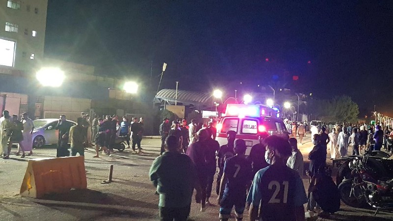 People gather outside a COVID-19 hospital in Nasiriyah, Iraq, early Tuesday, July 13, 2021. A catastrophic blaze erupted at the coronavirus hospital ward. It was the second time a large fire killed coronavirus patients in an Iraqi hospital this year. (AP Photo)