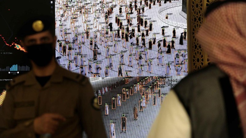 Saudi security personnel watch smart screens, which identify passing pilgrim's authorization to participate in the Hajj, at al Zaidy pilgrims reception center in Mecca, ahead of the upcoming annual pilgrimage, Monday, July 12, 2021. The pilgrimage to Mecca required once in a lifetime of every Muslim who can afford it and is physically able to make it, used to draw more than 2 million people. But for a second straight year it has been curtailed due to the coronavirus with only vaccinated people in Saudi Arabia able to participate. (AP Photo/Amr Nabil)