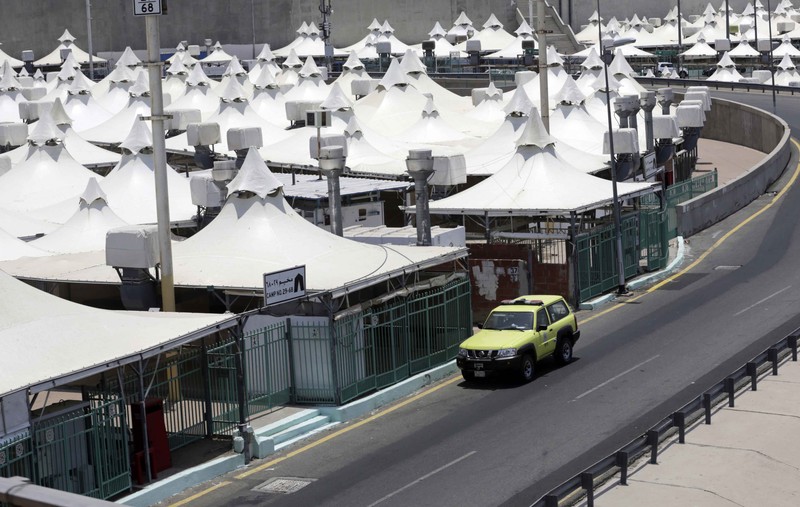 Saudi Arabia Hajj Saudi security personnel watch smart screens, which identify passing pilgrim's authorization to participate in the Hajj, at al Zaidy pilgrims reception center in Mecca, ahead of the upcoming annual pilgrimage, Monday, July 12, 2021. The pilgrimage to Mecca required once in a lifetime of every Muslim who can afford it and is physically able to make it, used to draw more than 2 million people. But for a second straight year it has been curtailed due to the coronavirus with only vaccinated people in Saudi Arabia able to participate. (AP Photo/Amr Nabil)