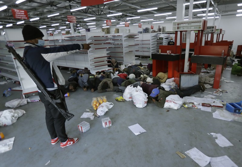 Kerusuhan di Afrika Selatan yang dipicu protes penahanan mantan presiden Yakub Zuma. Looters run as policer officers chassis at a shopping centre in Soweto, Johannesburg, Tuesd in Johannesburg, South Africa, Tuesday, July 13, 2021. South Africa's rioting continued Tuesday with the death toll rising to 32 as police and the military struggle to quell the violence in Gauteng and KwaZulu-Natal provinces. The violence started in various parts of KwaZulu-Natal last week when Zuma began serving a 15-month sentence for contempt of court. (AP Photo/Themba Hadebe)