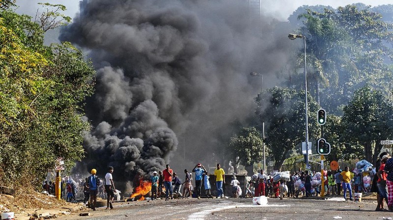 Looters run as policer officers chassis at a shopping centre in Soweto, Johannesburg, Tuesd in Johannesburg, South Africa, Tuesday, July 13, 2021. South Africa's rioting continued Tuesday with the death toll rising to 32 as police and the military struggle to quell the violence in Gauteng and KwaZulu-Natal provinces. The violence started in various parts of KwaZulu-Natal last week when Zuma began serving a 15-month sentence for contempt of court. (AP Photo/Themba Hadebe)