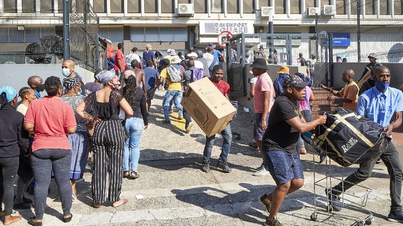 Looters run as policer officers chassis at a shopping centre in Soweto, Johannesburg, Tuesd in Johannesburg, South Africa, Tuesday, July 13, 2021. South Africa's rioting continued Tuesday with the death toll rising to 32 as police and the military struggle to quell the violence in Gauteng and KwaZulu-Natal provinces. The violence started in various parts of KwaZulu-Natal last week when Zuma began serving a 15-month sentence for contempt of court. (AP Photo/Themba Hadebe)