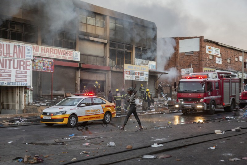 Looters run as policer officers chassis at a shopping centre in Soweto, Johannesburg, Tuesd in Johannesburg, South Africa, Tuesday, July 13, 2021. South Africa's rioting continued Tuesday with the death toll rising to 32 as police and the military struggle to quell the violence in Gauteng and KwaZulu-Natal provinces. The violence started in various parts of KwaZulu-Natal last week when Zuma began serving a 15-month sentence for contempt of court. (AP Photo/Themba Hadebe)