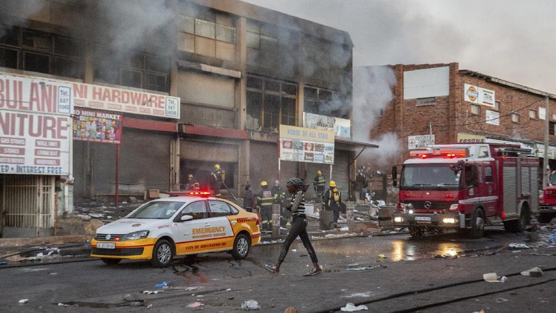 Looters run as policer officers chassis at a shopping centre in Soweto, Johannesburg, Tuesd in Johannesburg, South Africa, Tuesday, July 13, 2021. South Africa's rioting continued Tuesday with the death toll rising to 32 as police and the military struggle to quell the violence in Gauteng and KwaZulu-Natal provinces. The violence started in various parts of KwaZulu-Natal last week when Zuma began serving a 15-month sentence for contempt of court. (AP Photo/Themba Hadebe)