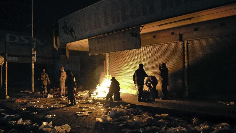 Looters run as policer officers chassis at a shopping centre in Soweto, Johannesburg, Tuesd in Johannesburg, South Africa, Tuesday, July 13, 2021. South Africa's rioting continued Tuesday with the death toll rising to 32 as police and the military struggle to quell the violence in Gauteng and KwaZulu-Natal provinces. The violence started in various parts of KwaZulu-Natal last week when Zuma began serving a 15-month sentence for contempt of court. (AP Photo/Themba Hadebe)