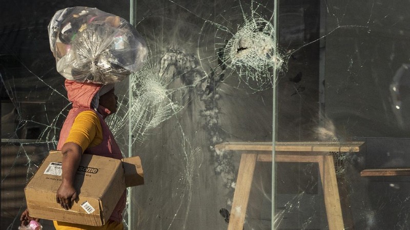 Looters run as policer officers chassis at a shopping centre in Soweto, Johannesburg, Tuesd in Johannesburg, South Africa, Tuesday, July 13, 2021. South Africa's rioting continued Tuesday with the death toll rising to 32 as police and the military struggle to quell the violence in Gauteng and KwaZulu-Natal provinces. The violence started in various parts of KwaZulu-Natal last week when Zuma began serving a 15-month sentence for contempt of court. (AP Photo/Themba Hadebe)
