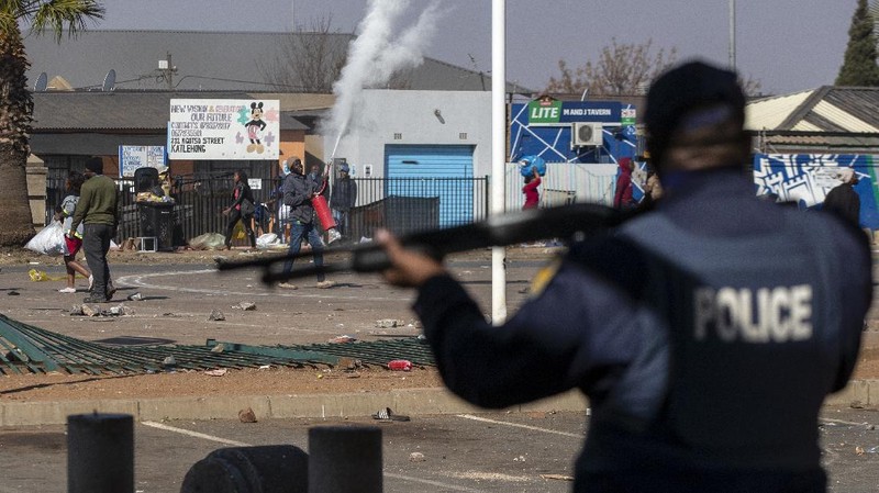 Looters run as policer officers chassis at a shopping centre in Soweto, Johannesburg, Tuesd in Johannesburg, South Africa, Tuesday, July 13, 2021. South Africa's rioting continued Tuesday with the death toll rising to 32 as police and the military struggle to quell the violence in Gauteng and KwaZulu-Natal provinces. The violence started in various parts of KwaZulu-Natal last week when Zuma began serving a 15-month sentence for contempt of court. (AP Photo/Themba Hadebe)