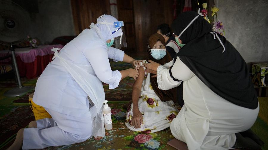 A nurse administers a Pfizer COVID-19 vaccine to an elderly man in his house in rural Sabab Bernam, central Selangor state, Malaysia, Tuesday, July 13, 2021. Medical teams are going house to house in rural villages to reach out to elderly citizens as the government seeks to ramp up its vaccination program. Despite a strict lockdown, the pandemic has worsened with more than 844,000 confirmed cases nationwide and over 6,200 deaths. (AP Photo/Vincent Thian)