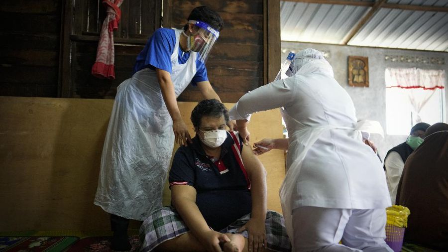 A nurse administers a Pfizer COVID-19 vaccine to an elderly man in his house in rural Sabab Bernam, central Selangor state, Malaysia, Tuesday, July 13, 2021. Medical teams are going house to house in rural villages to reach out to elderly citizens as the government seeks to ramp up its vaccination program. Despite a strict lockdown, the pandemic has worsened with more than 844,000 confirmed cases nationwide and over 6,200 deaths. (AP Photo/Vincent Thian)