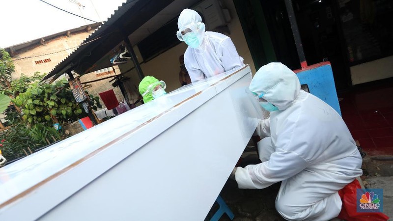 Sejumlah satgas pemulasaran jenazah covid-19 bersiap untuk memakamkan jenazah covid-19 yang meninggal saat isolasi mandiri di Jalan Camat Gabung, Jagakarsa, Lenteng agung, Jakarta, Jumat (16/7/2021). (CNBC Indonesia/Andrean Kristianto)