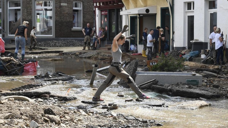 Helpers check for victims in flooded cars on a road in Erftstadt, Germany, Saturday, July 17, 2021. Due to strong rainfall,  the small Erft river went over its banks,  causing massive damage. (AP Photo/Michael Probst)