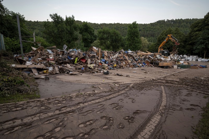 Helpers check for victims in flooded cars on a road in Erftstadt, Germany, Saturday, July 17, 2021. Due to strong rainfall,  the small Erft river went over its banks,  causing massive damage. (AP Photo/Michael Probst)