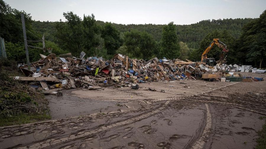 Helpers check for victims in flooded cars on a road in Erftstadt, Germany, Saturday, July 17, 2021. Due to strong rainfall,  the small Erft river went over its banks,  causing massive damage. (AP Photo/Michael Probst)