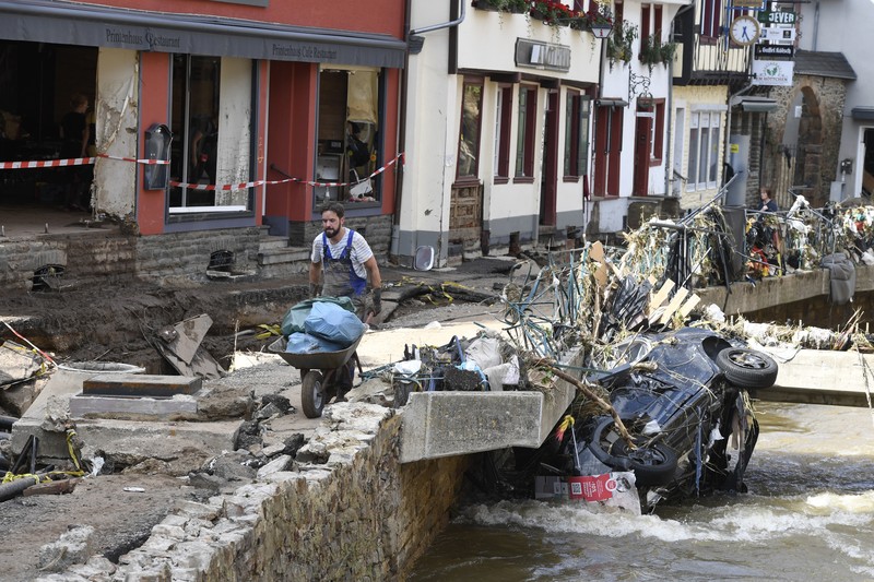 Helpers check for victims in flooded cars on a road in Erftstadt, Germany, Saturday, July 17, 2021. Due to strong rainfall,  the small Erft river went over its banks,  causing massive damage. (AP Photo/Michael Probst)