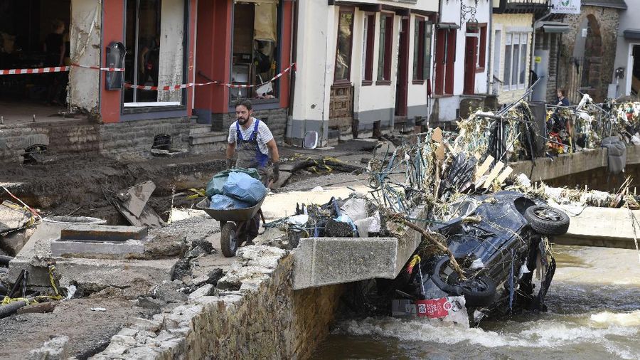 Helpers check for victims in flooded cars on a road in Erftstadt, Germany, Saturday, July 17, 2021. Due to strong rainfall,  the small Erft river went over its banks,  causing massive damage. (AP Photo/Michael Probst)