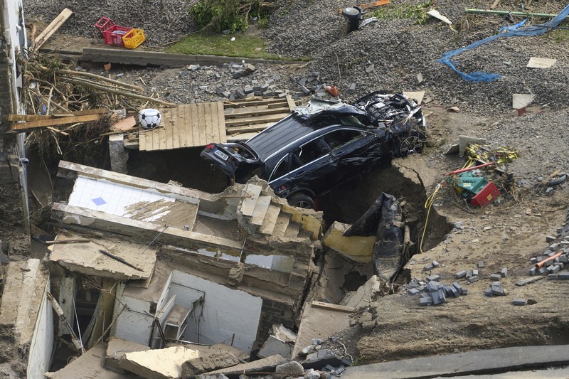 Helpers check for victims in flooded cars on a road in Erftstadt, Germany, Saturday, July 17, 2021. Due to strong rainfall,  the small Erft river went over its banks,  causing massive damage. (AP Photo/Michael Probst)