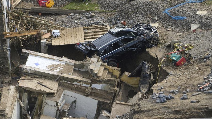 Helpers check for victims in flooded cars on a road in Erftstadt, Germany, Saturday, July 17, 2021. Due to strong rainfall,  the small Erft river went over its banks,  causing massive damage. (AP Photo/Michael Probst)