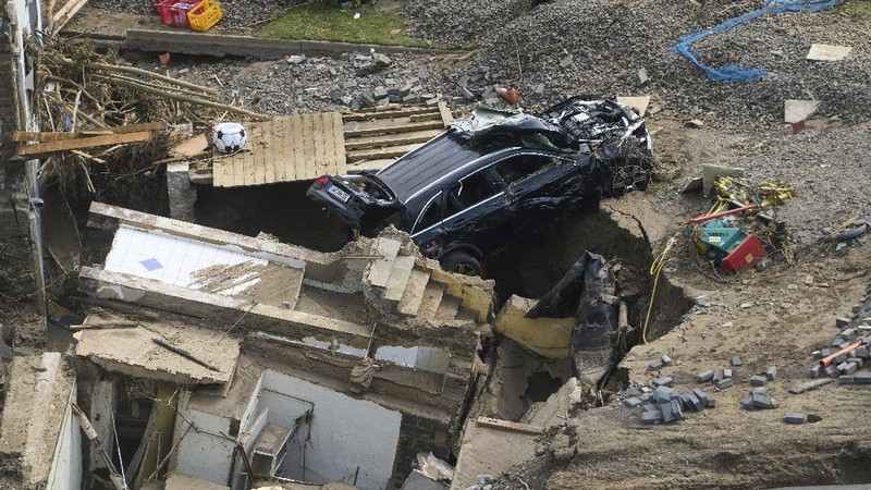 Helpers check for victims in flooded cars on a road in Erftstadt, Germany, Saturday, July 17, 2021. Due to strong rainfall,  the small Erft river went over its banks,  causing massive damage. (AP Photo/Michael Probst)