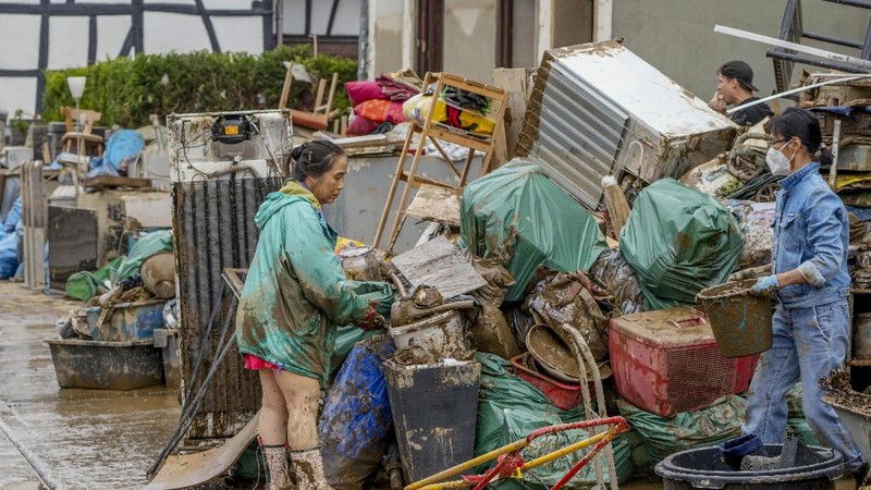 Helpers check for victims in flooded cars on a road in Erftstadt, Germany, Saturday, July 17, 2021. Due to strong rainfall,  the small Erft river went over its banks,  causing massive damage. (AP Photo/Michael Probst)