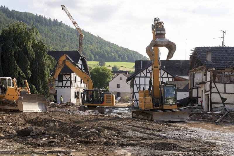 Helpers check for victims in flooded cars on a road in Erftstadt, Germany, Saturday, July 17, 2021. Due to strong rainfall,  the small Erft river went over its banks,  causing massive damage. (AP Photo/Michael Probst)