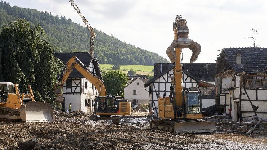 Helpers check for victims in flooded cars on a road in Erftstadt, Germany, Saturday, July 17, 2021. Due to strong rainfall,  the small Erft river went over its banks,  causing massive damage. (AP Photo/Michael Probst)