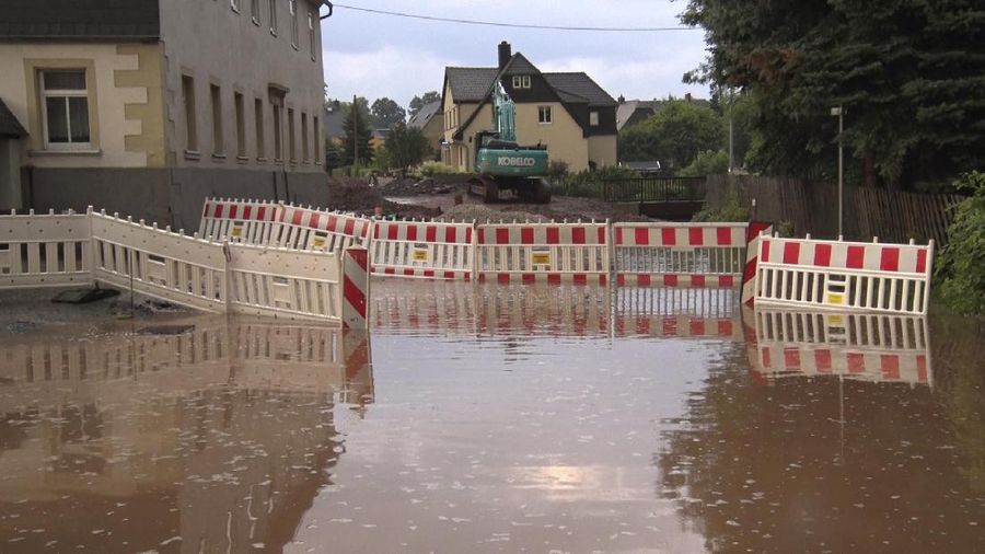 A road is flooded after severe weather in Oberlungwitz, Germany, Saturday, July 17, 2021. Days of heavy rain turned normally minor rivers and streets into raging torrents this week and caused the disastrous flooding that swept away cars, engulfed homes and trapped residents. (Andr' M'rz/dpa via AP)