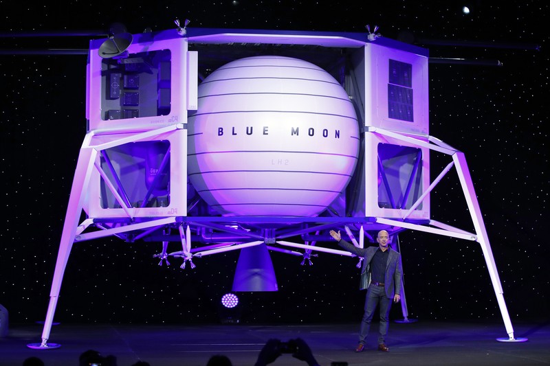 FILE - In this Thursday, May 9, 2019 file phto, Jeff Bezos speaks in front of a model of Blue Origin's Blue Moon lunar lander in Washington. In 2020, NASA Administrator Jim Bridenstine said space is currently a $400 billion market, including satellites. Opening up spaceflight to paying customers, he said, could expand the market to $1 trillion. (AP Photo/Patrick Semansky)