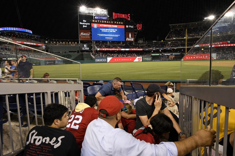 Penemabakan di Luar Stadion AS Saat Pertandingan Baseball Fans jump into a camera well after hearing gunfire from outside the stadium, during a baseball game between the San Diego Padres and the Washington Nationals at Nationals Park in Washington on Saturday, July 17, 2021. (John McDonnell/The Washington Post via AP)