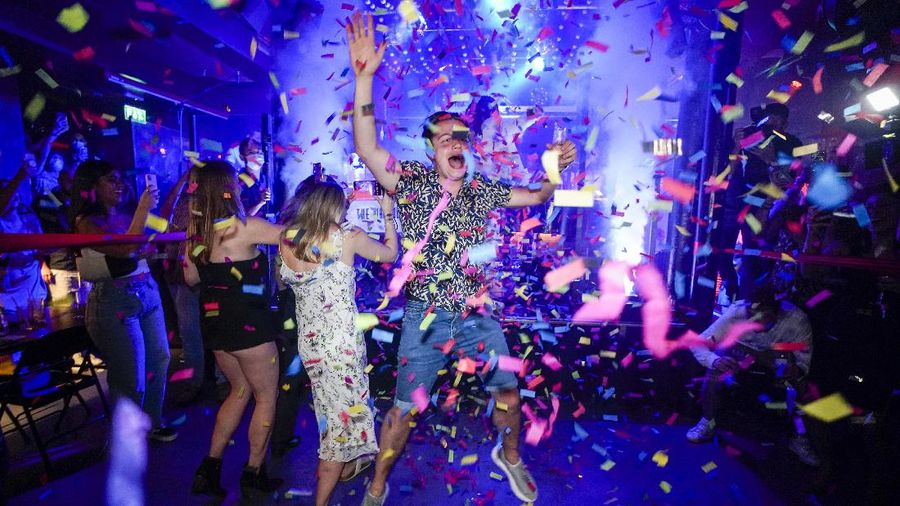 A man jumps on the dance floor shortly after the reopening, at The Piano Works in Farringdon, in London, Monday, July 19, 2021. The country's nightclubs are reopening for the first time in 17 months as almost all coronavirus rules are set to be scrapped. (AP Photo/Alberto Pezzali)