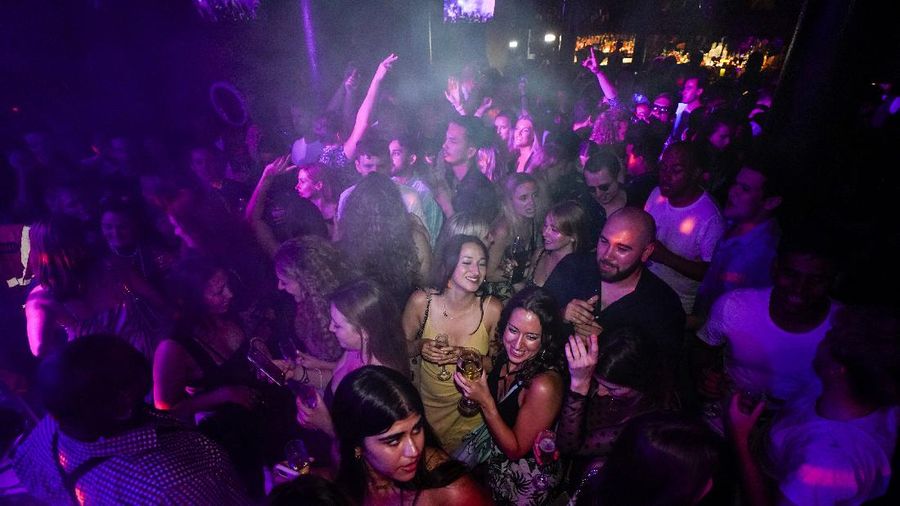 People drink on the dance floor shortly after the reopening, at The Piano Works in Farringdon, in London, Monday, July 19, 2021. Thousands of young people plan to dance the night away at 'Freedom Day' parties after midnight Sunday, when almost all coronavirus restrictions in England are to be scrapped. Nightclubs, which have been shuttered since March 2020, can finally reopen. (AP Photo/Alberto Pezzali)