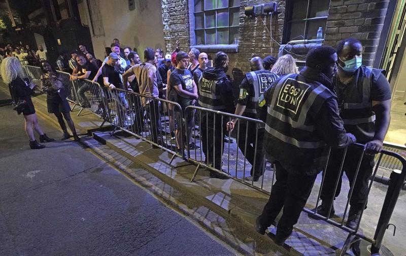 People celebrate as they queue up for entry at the Viaduct Bar in Leeds, after the final legal coronavirus restrictions were lifted in England at midnight, Monday, July 19, 2021. (Ioannis Alexopoulos/PA via AP)