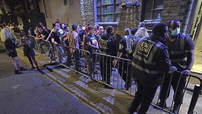 People celebrate as they queue up for entry at the Viaduct Bar in Leeds, after the final legal coronavirus restrictions were lifted in England at midnight, Monday, July 19, 2021. (Ioannis Alexopoulos/PA via AP)