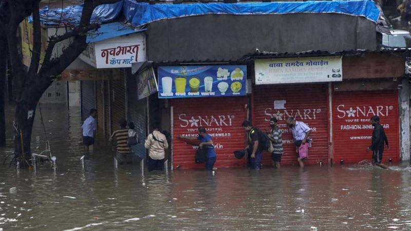 Rescuers carry a dead body of a man after a wall collapsed on several slum houses heavy monsoon rains in the Mahul area of Mumbai, India, Sunday, July 18, 2021. More than a dozen people were killed in the incident. (AP Photo/Rajanish Kakade)