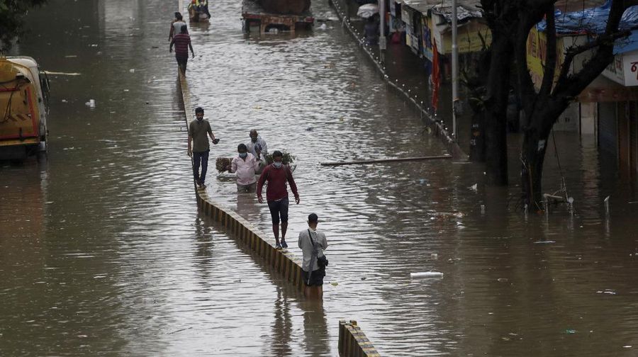 Rescuers carry a dead body of a man after a wall collapsed on several slum houses heavy monsoon rains in the Mahul area of Mumbai, India, Sunday, July 18, 2021. More than a dozen people were killed in the incident. (AP Photo/Rajanish Kakade)