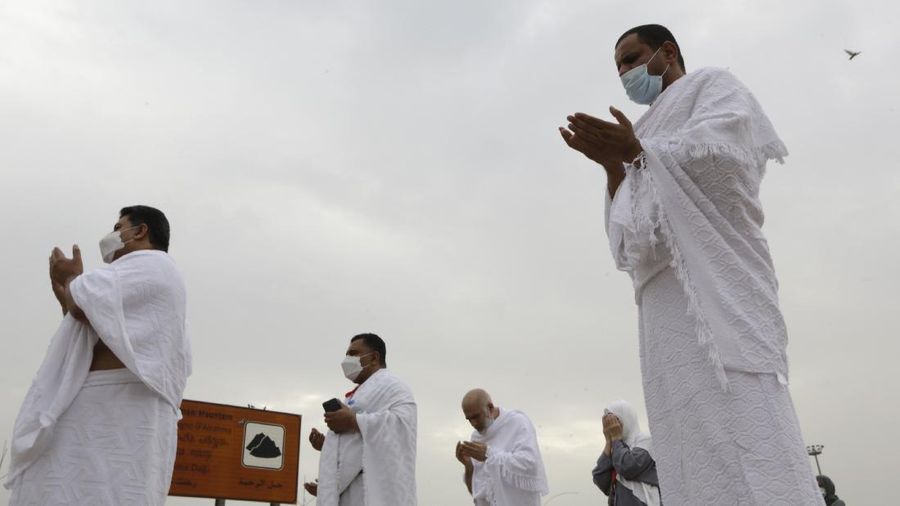Muslim pilgrims pray in front of the rocky hill known as Mountain of Mercy, on the Plain of Arafat, during the annual hajj pilgrimage, near the holy city of Mecca, Saudi Arabia, Monday, July 19, 2021. Tens of thousands of vaccinated Muslim pilgrims circled Islam's holiest site in Mecca on Sunday, but remained socially distanced and wore masks as the coronavirus takes its toll on the hajj for a second year running. What once drew some 2.5 million Muslims from all walks of life from across the globe, the hajj pilgrimage is now almost unrecognizable in scale. (AP Photo/Amr Nabil)