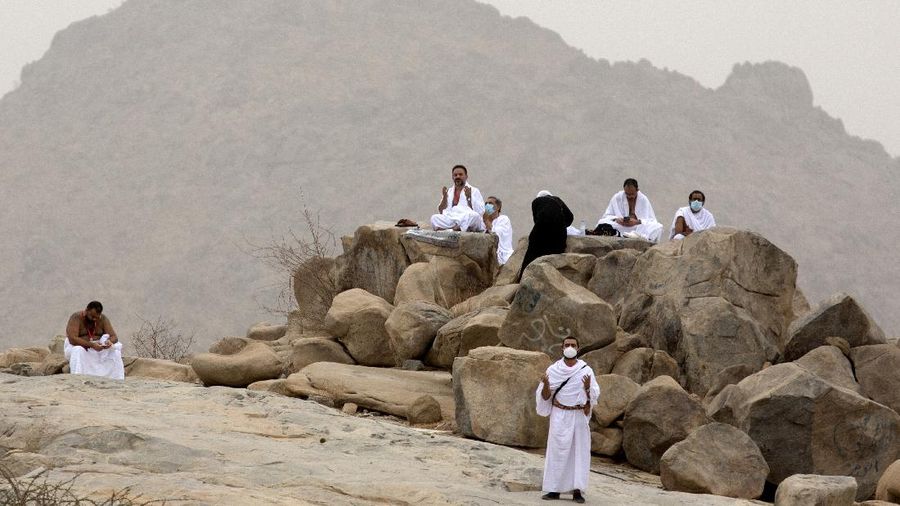 Muslim pilgrims pray near the rocky hill known as Mountain of Mercy, on the Plain of Arafat, during the annual hajj pilgrimage, near the holy city of Mecca, Saudi Arabia, Monday, July 19, 2021. Tens of thousands of vaccinated Muslim pilgrims circled Islam's holiest site in Mecca on Sunday, but remained socially distanced and wore masks as the coronavirus takes its toll on the hajj for a second year running. What once drew some 2.5 million Muslims from all walks of life from across the globe, the hajj pilgrimage is now almost unrecognizable in scale. (AP Photo/Amr Nabil)