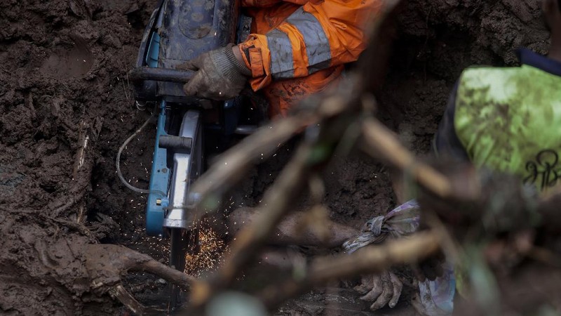 Rescuers carry a dead body of a man after a wall collapsed on several slum houses heavy monsoon rains in the Mahul area of Mumbai, India, Sunday, July 18, 2021. More than a dozen people were killed in the incident. (AP Photo/Rajanish Kakade)