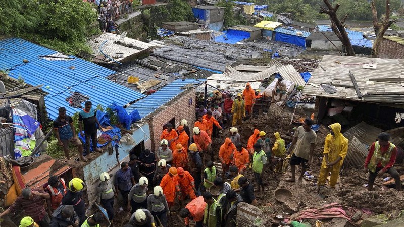Rescuers carry a dead body of a man after a wall collapsed on several slum houses heavy monsoon rains in the Mahul area of Mumbai, India, Sunday, July 18, 2021. More than a dozen people were killed in the incident. (AP Photo/Rajanish Kakade)