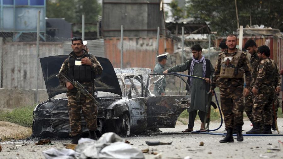 Security personnel inspect a damaged vehicle where rockets were fired from in Kabul, Afghanistan, Tuesday, July 20, 2021. At least three rockets hit near the presidential palace on Tuesday shortly before Afghan President Ashraf Ghani was to give an address to mark the Muslim holiday of Eid-al-Adha. (AP Photo/Rahmat Gul)
