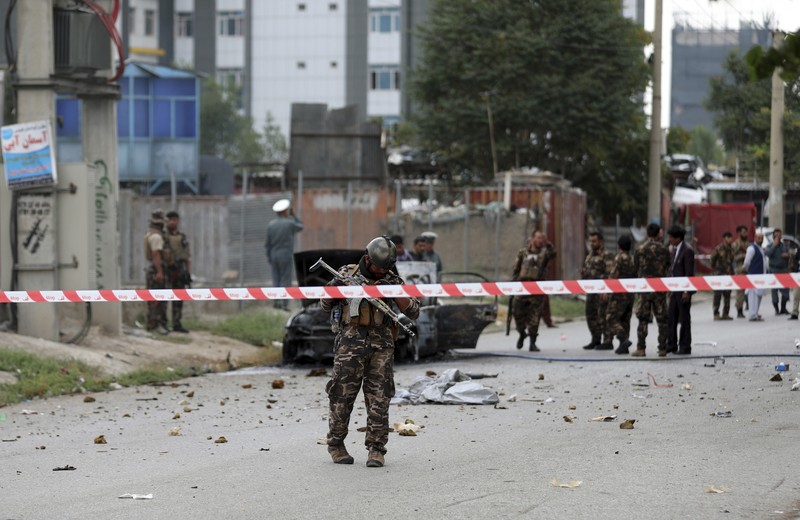 Security personnel inspect a damaged vehicle where rockets were fired from in Kabul, Afghanistan, Tuesday, July 20, 2021. At least three rockets hit near the presidential palace on Tuesday shortly before Afghan President Ashraf Ghani was to give an address to mark the Muslim holiday of Eid-al-Adha. (AP Photo/Rahmat Gul)