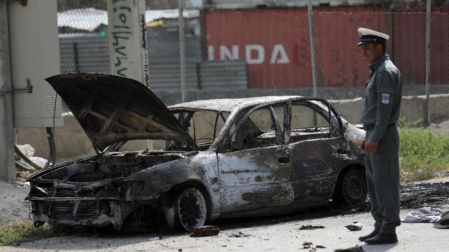 Security personnel inspect a damaged vehicle where rockets were fired from in Kabul, Afghanistan, Tuesday, July 20, 2021. At least three rockets hit near the presidential palace on Tuesday shortly before Afghan President Ashraf Ghani was to give an address to mark the Muslim holiday of Eid-al-Adha. (AP Photo/Rahmat Gul)