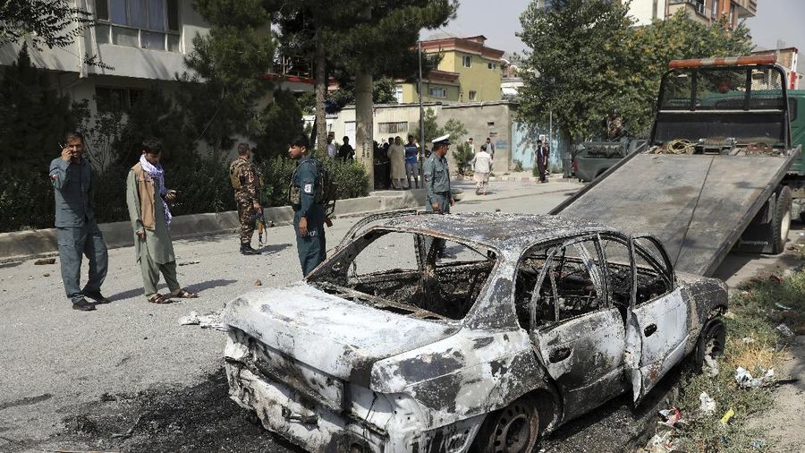 Security personnel inspect a damaged vehicle where rockets were fired from in Kabul, Afghanistan, Tuesday, July 20, 2021. At least three rockets hit near the presidential palace on Tuesday shortly before Afghan President Ashraf Ghani was to give an address to mark the Muslim holiday of Eid-al-Adha. (AP Photo/Rahmat Gul)