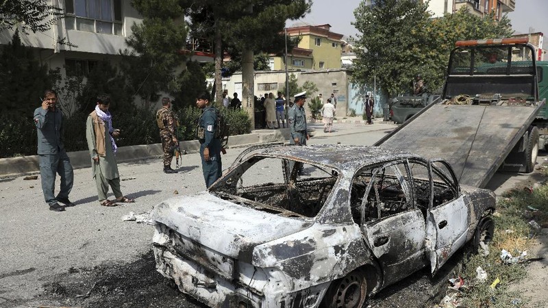 Security personnel inspect a damaged vehicle where rockets were fired from in Kabul, Afghanistan, Tuesday, July 20, 2021. At least three rockets hit near the presidential palace on Tuesday shortly before Afghan President Ashraf Ghani was to give an address to mark the Muslim holiday of Eid-al-Adha. (AP Photo/Rahmat Gul)