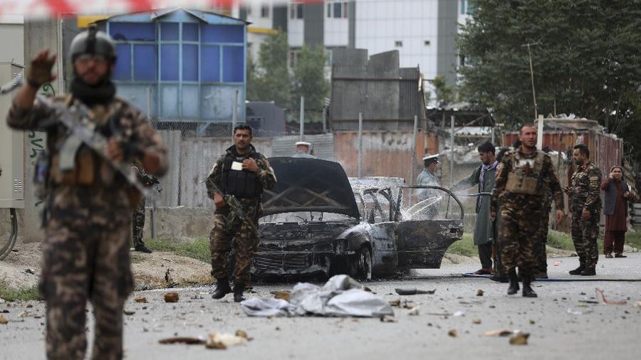 Security personnel inspect a damaged vehicle where rockets were fired from in Kabul, Afghanistan, Tuesday, July 20, 2021. At least three rockets hit near the presidential palace on Tuesday shortly before Afghan President Ashraf Ghani was to give an address to mark the Muslim holiday of Eid-al-Adha. (AP Photo/Rahmat Gul)