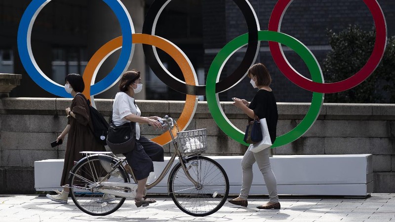 Lightning illuminates the sky over the Olympic rings and the Rainbow Bridge in Tokyo, Sunday, July 11, 2021. The opening ceremony of the postponed 2020 Summer Olympics is scheduled to be held in less than two weeks. (Kyodo News via AP)