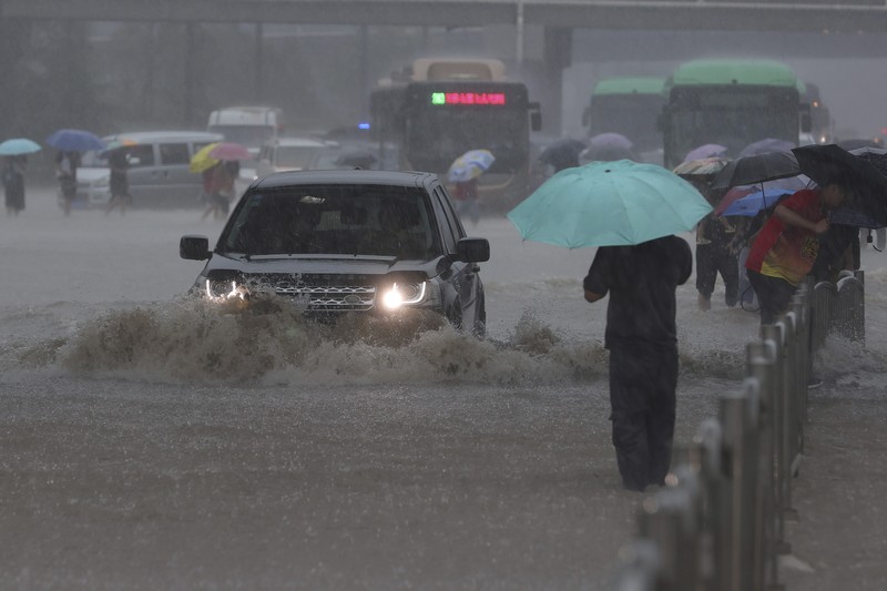Banjir di China Vehicles are stranded after a heavy downpour in Zhengzhou city, central China's Henan province on Tuesday, July 20, 2021. Heavy flooding has hit central China following unusually heavy rains, with the subway system in the city of Zhengzhou inundated with rushing water. (Chinatopix Via AP)
