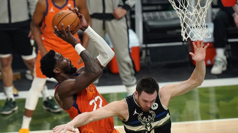 Phoenix Suns guard Devin Booker (1) works the ball against Milwaukee Bucks guard Bryn Forbes (7) during the first half of Game 6 of basketball's NBA Finals Tuesday, July 20, 2021, in Milwaukee. (AP Photo/Aaron Gash)